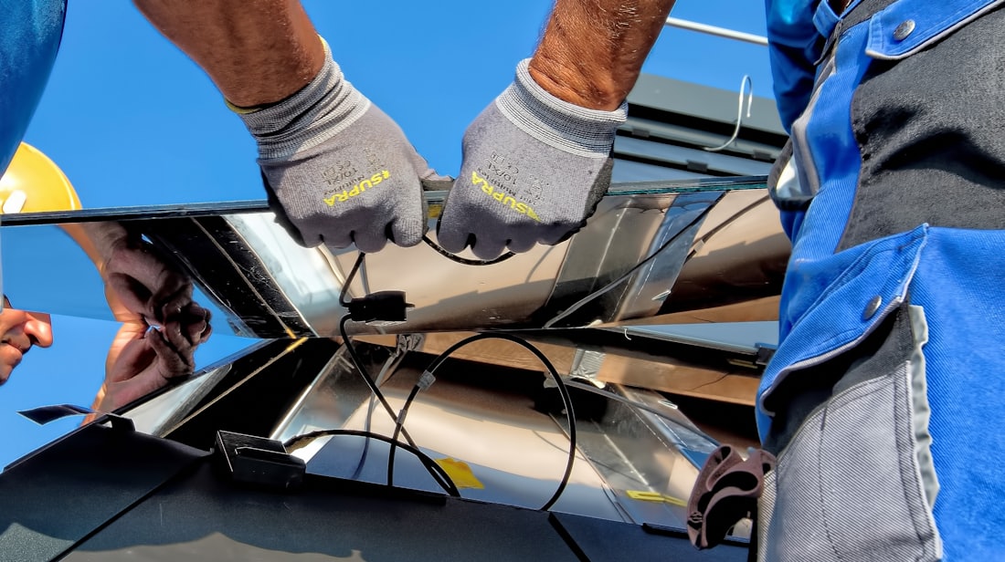 Installer terminating DC conductors at a solar panel junction box