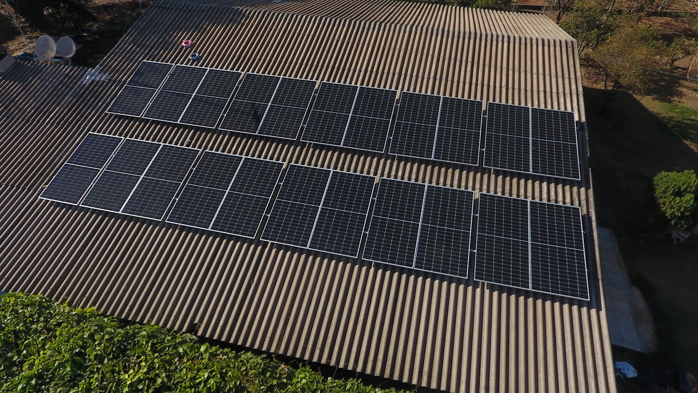 Rooftop solar array photographed from above, panels in rows on a timber roof deck